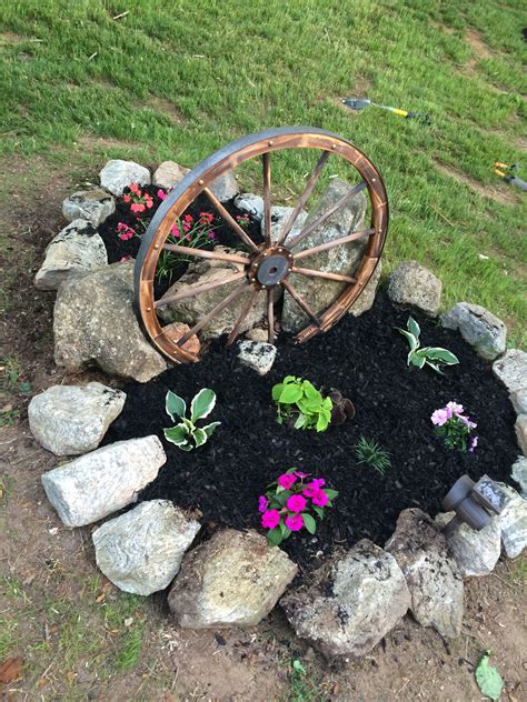 Wagon wheel with flowers for entrance into our home I love this look | Wagon wheel garden ...