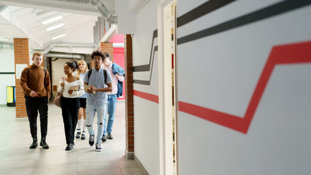 Group of diverse high school students walking through the hall