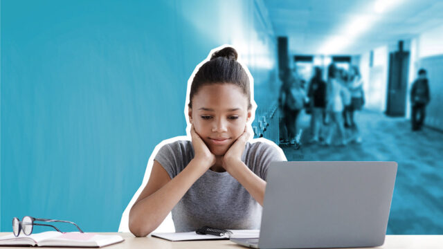 Young African American student sitting at desk with her face in her hands.