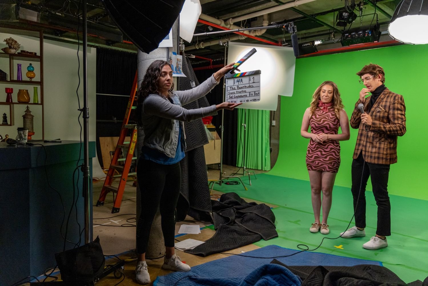 two show hosts in front of a green screen in a studio