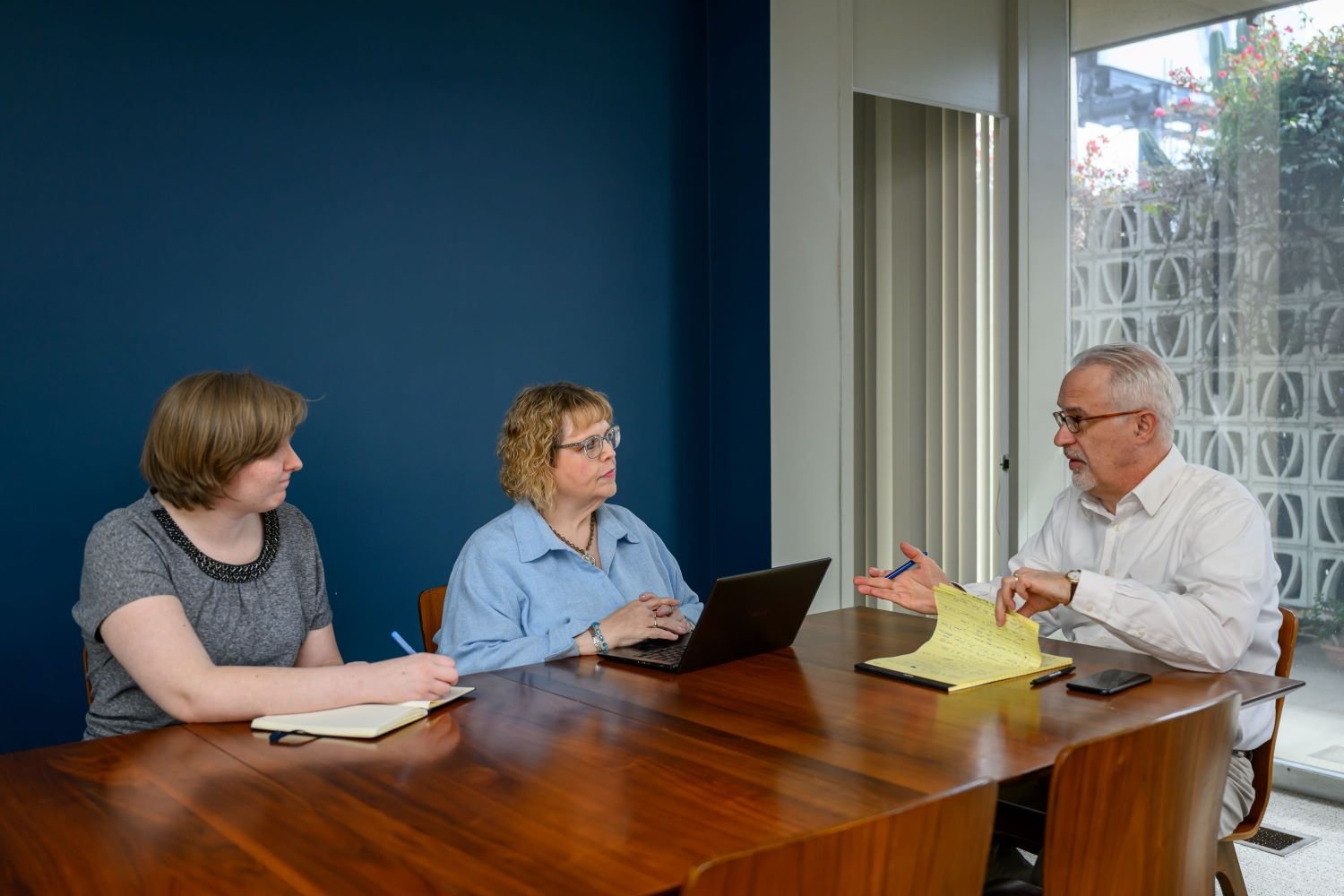 three team members sitting at a conference table