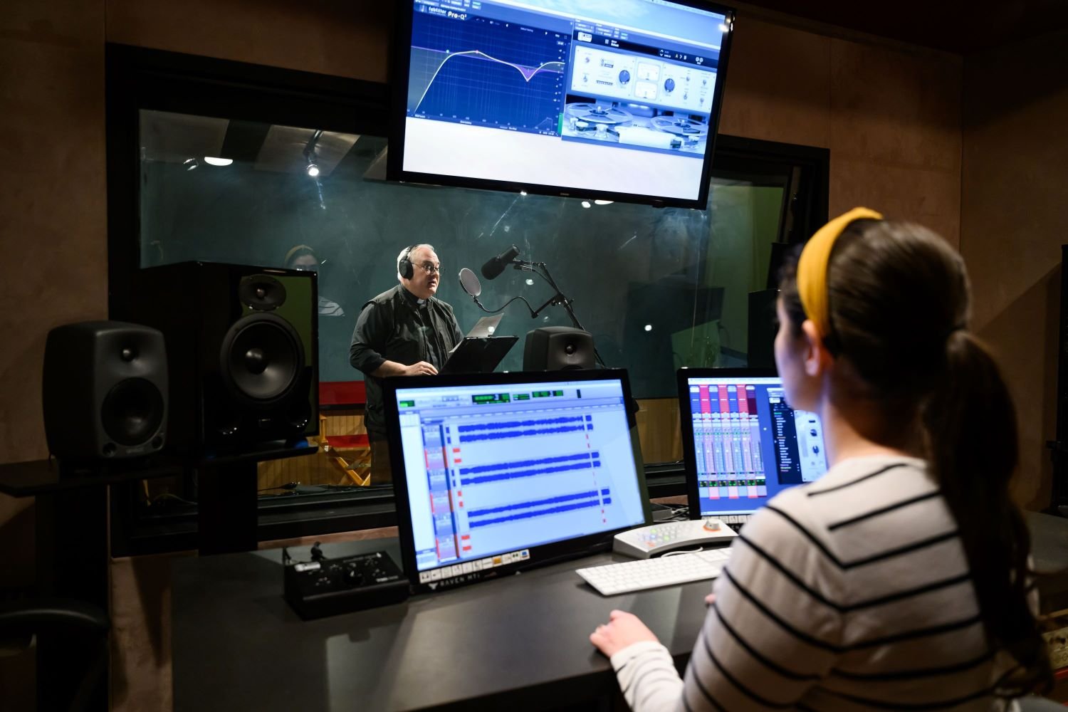 a sound technician helping a voice actor in the recording studio