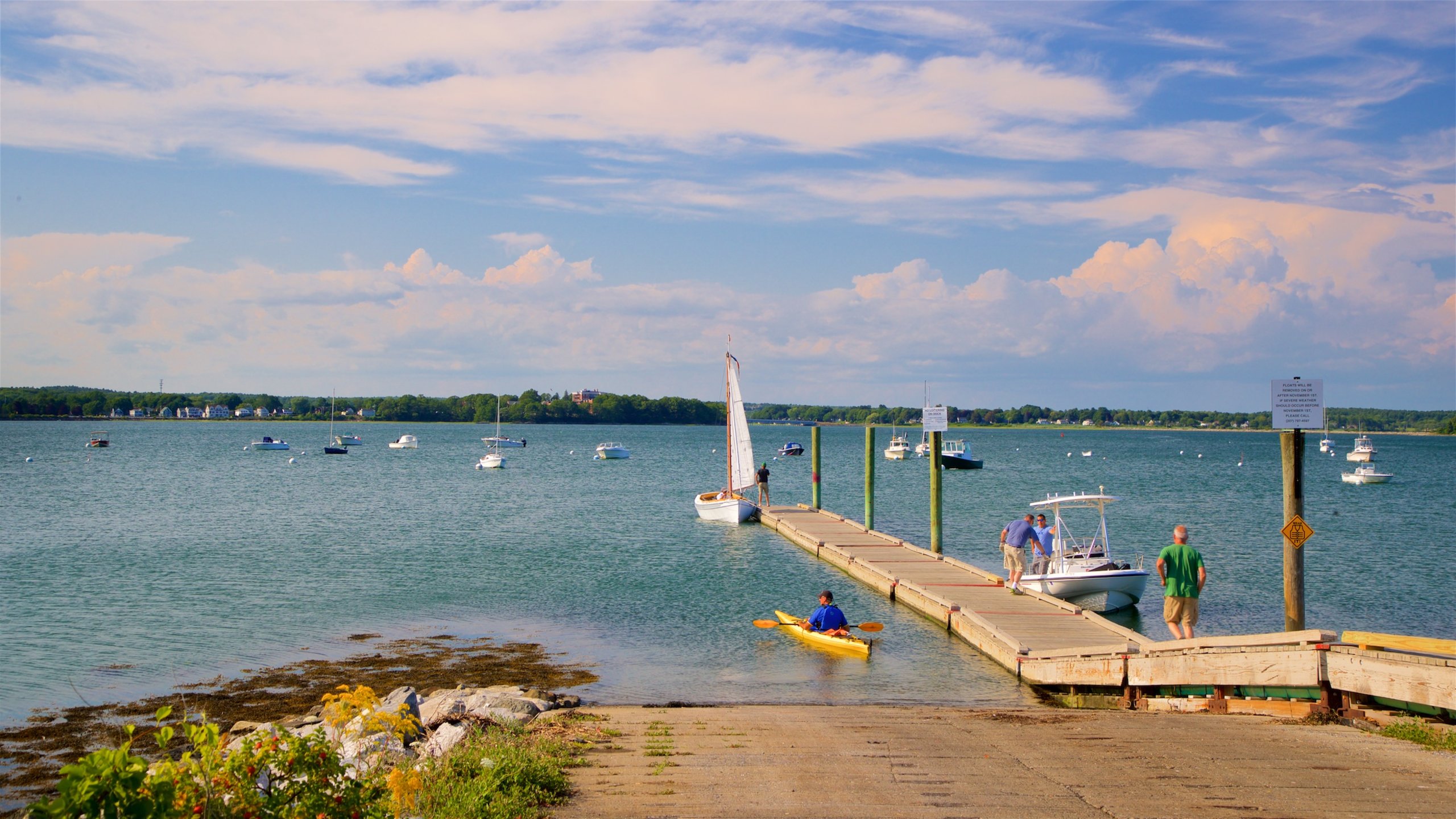 Eastern Promenade which includes a bay or harbour and general coastal views as well as a small group of people