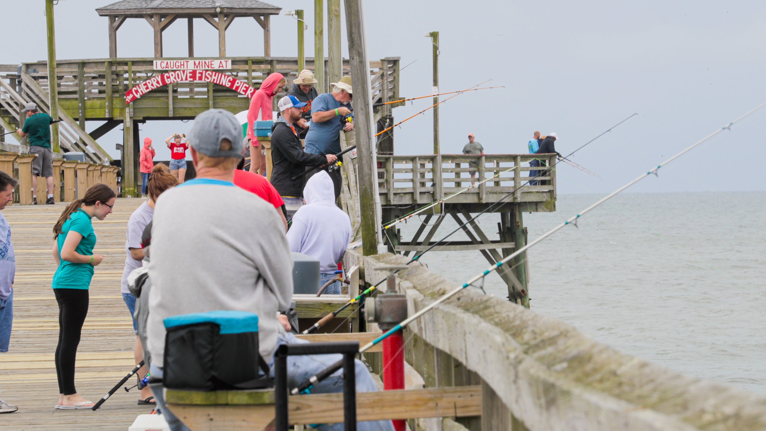 Cherry Grove Pier showing general coastal views and fishing as well as a small group of people