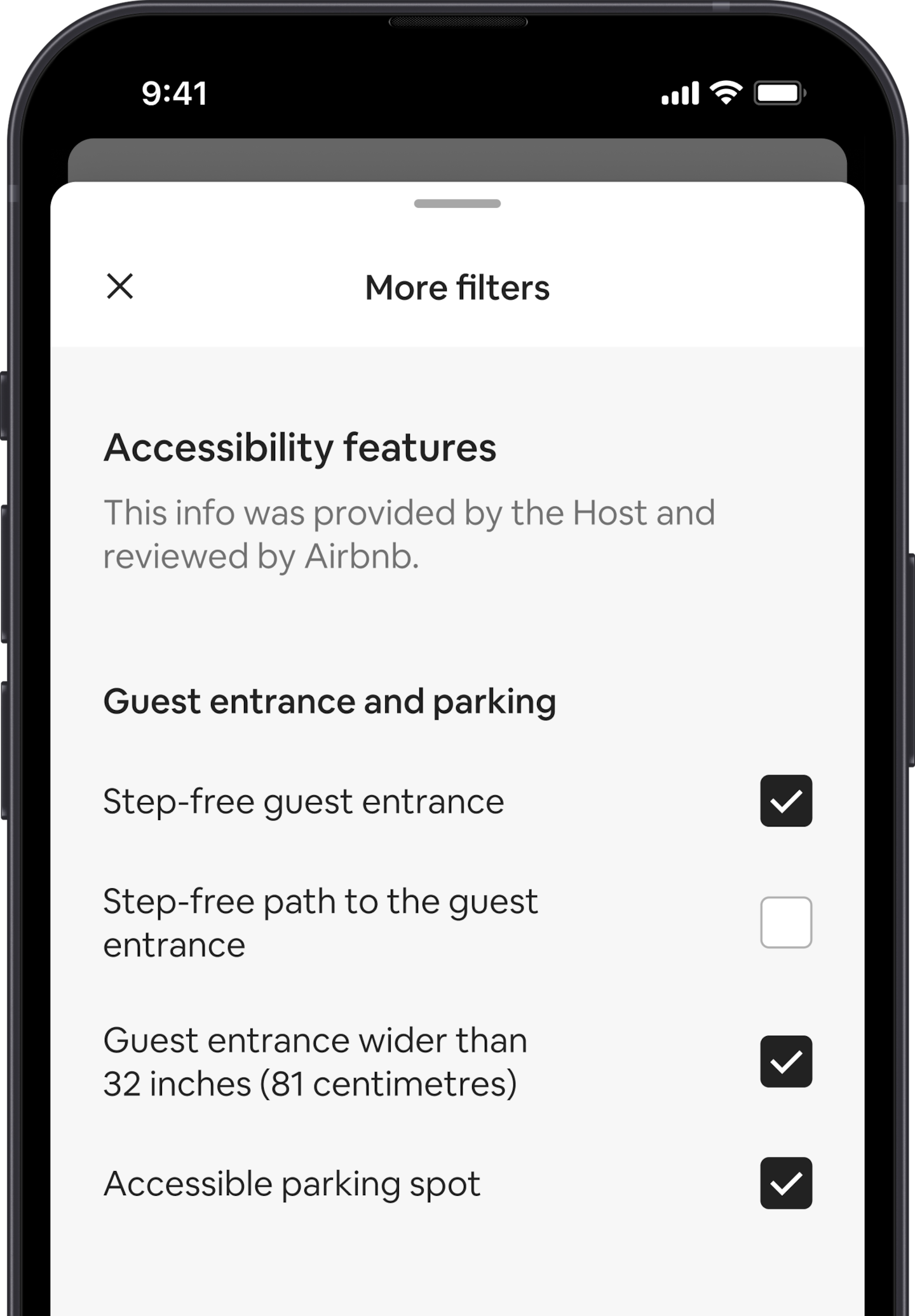 A mobile phone displays the More filters overlay, which is one of many search filters. There is a section heading that reads "Accessibility Features". Below that, accessibility features are grouped by areas like “Guest entrance and parking”. There are tickboxes where you can select as many features as you want.