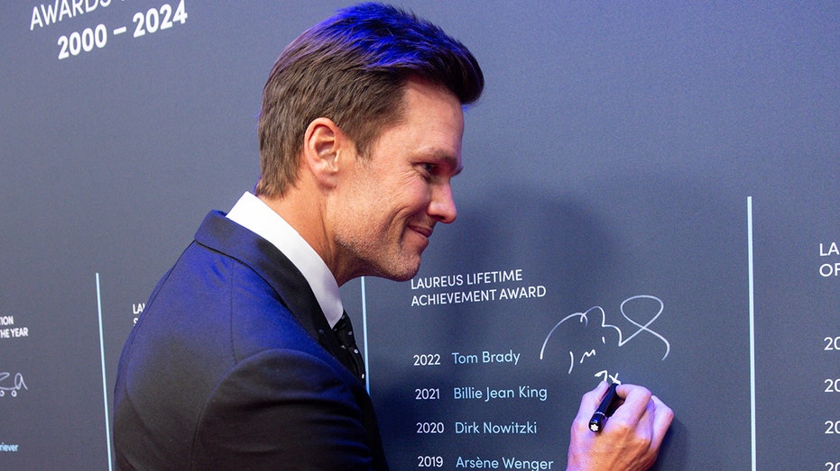 Tom Brady signs a wall