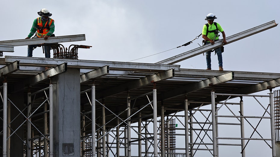 Construction workers help build an apartment in Los Angeles