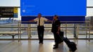 United Airlines employees wait by a departures monitor displaying a blue error screen after United Airlines and other airlines grounded flights due to a worldwide tech outage caused by an update to CrowdStrikes &quot;Falcon Sensor&quot; software which crashed Microsoft Windows systems, in Newark, New Jersey, U.S., July 19, 2024. REUTERS/Bing Guan