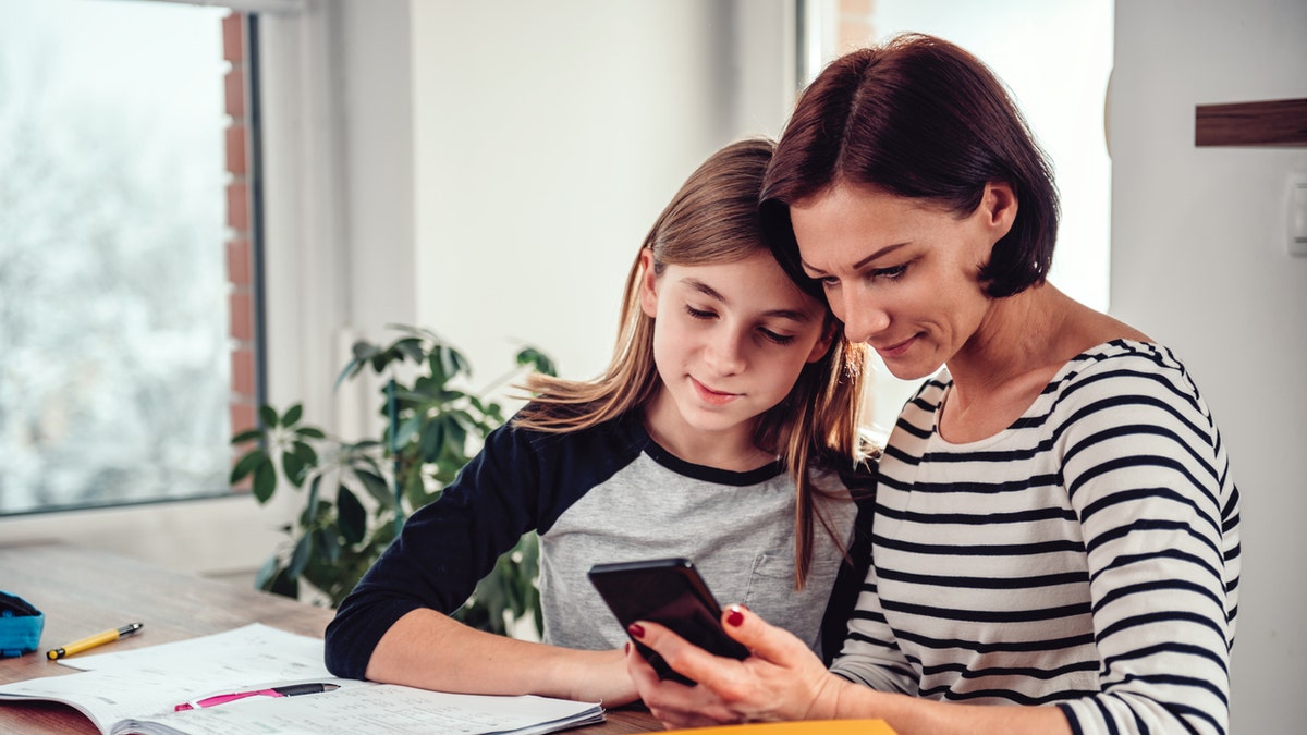 A mother and daughter looking at a phone