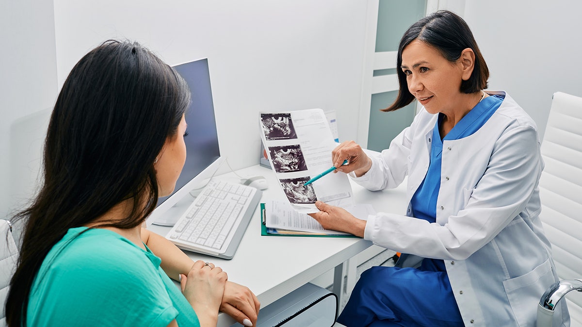 fertility doctor with patient's sonogram