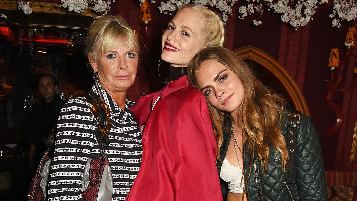 Cara Delevingne poses for a photo with sister Poppy and mother Pandora