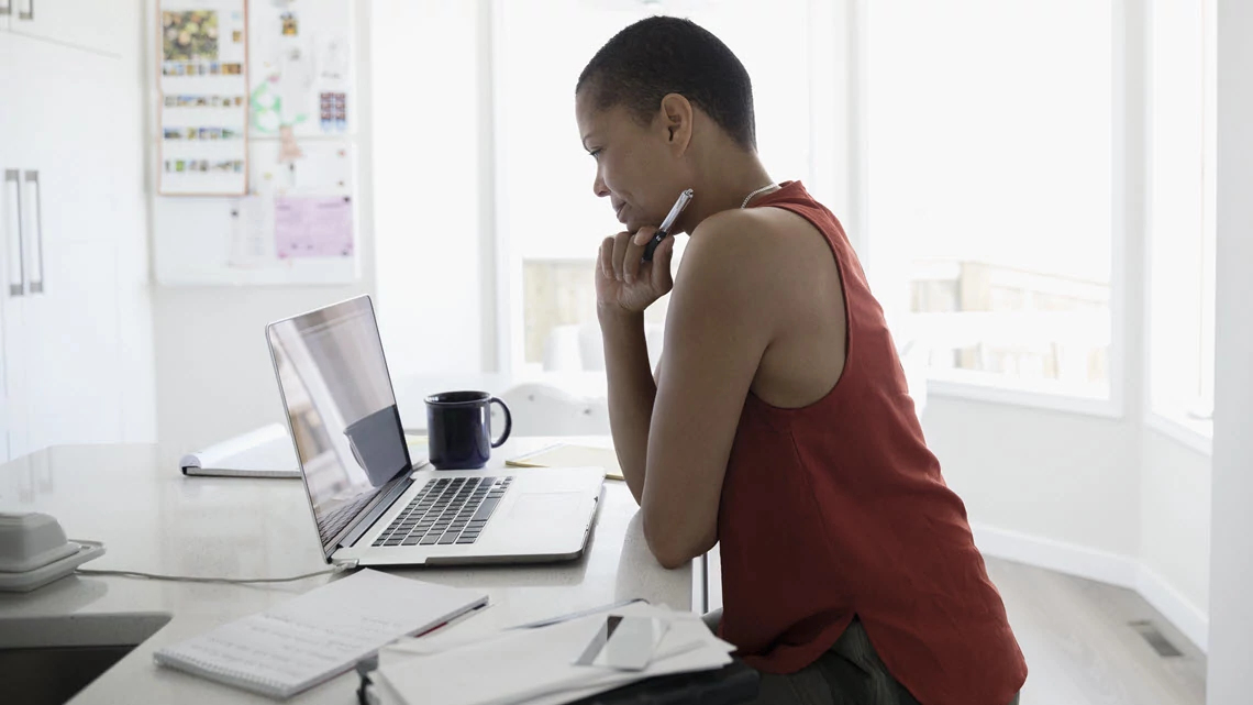 Una mujer mira una computadora.