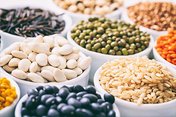 a group of ceramic bowls containing grains and legumes