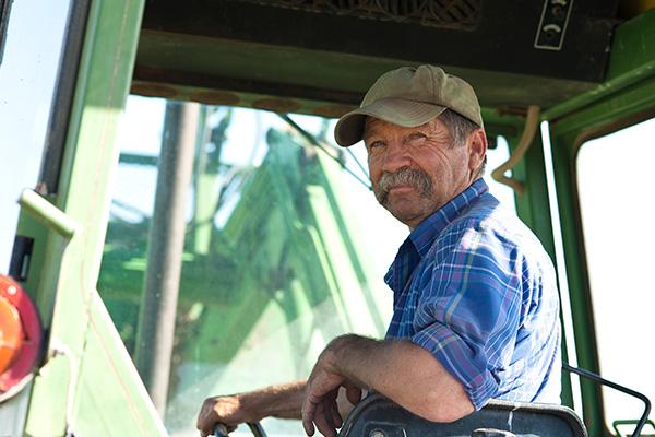 a male farmer sitting in a combine