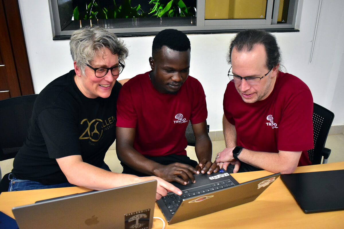 Two researchers work with a student.