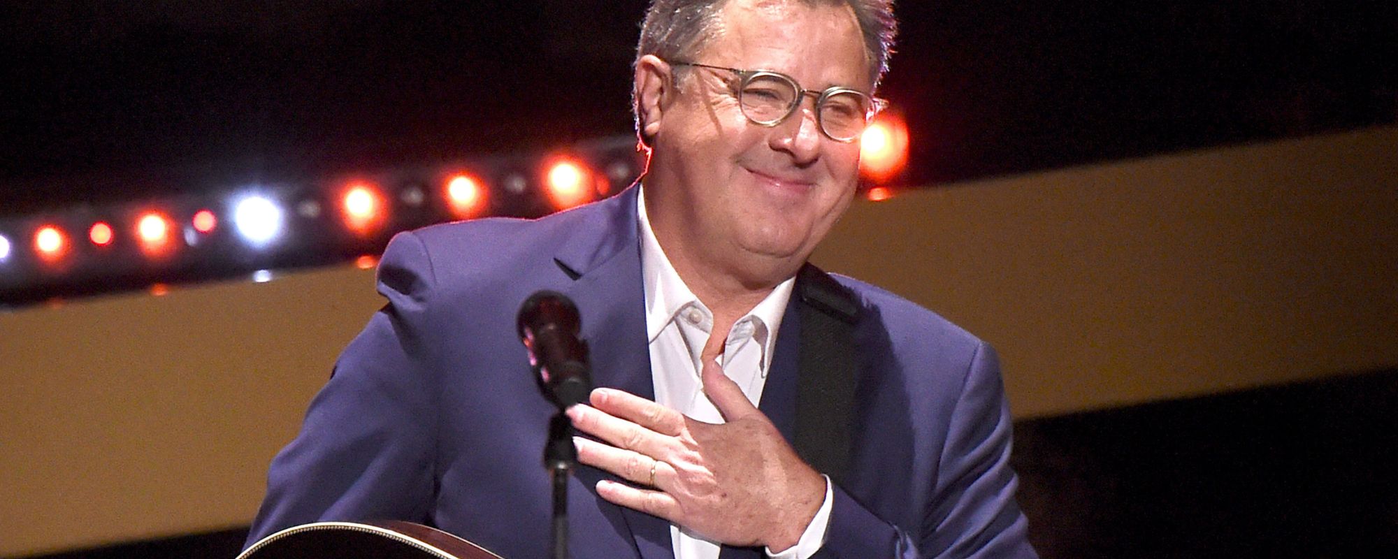 Vince Gill smiling with hand on chest