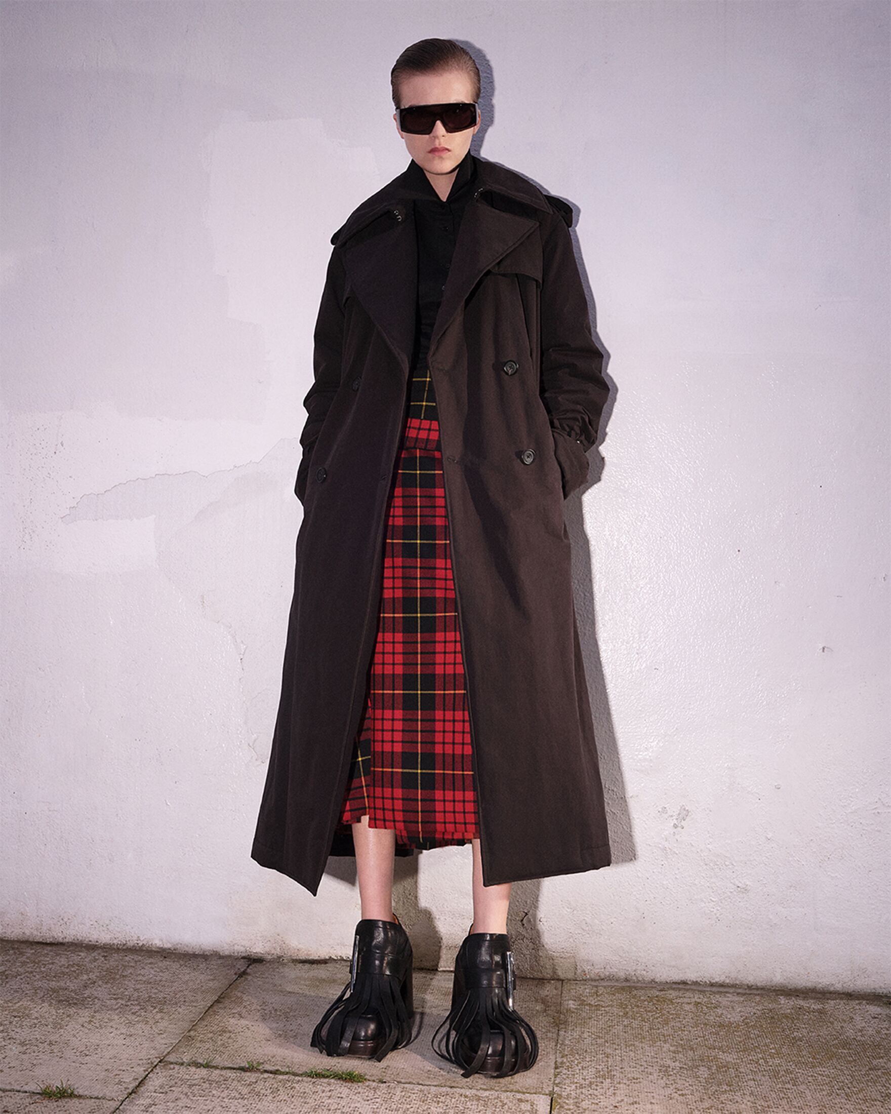 Model wearing red tartan skirt and a coat