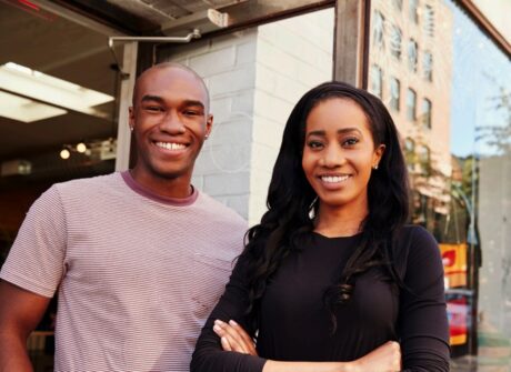 Two people standing side by side, smiling about AOF's non-profit lending model