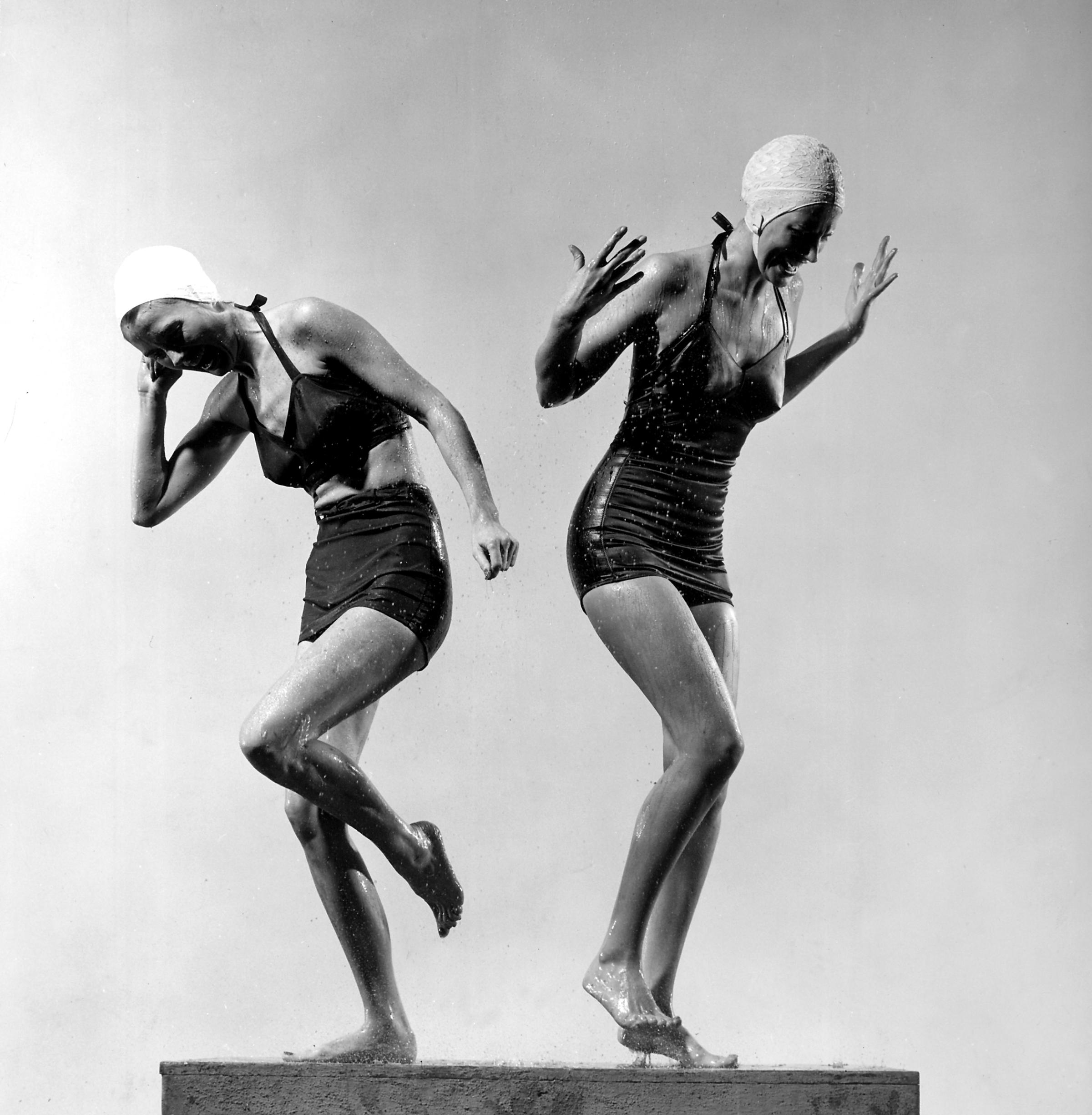 Two models wearing bathing suits and bathing caps, circa 1946.