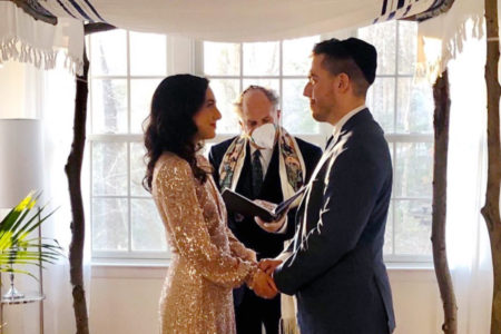 Wedding couple under a chuppah in their living room