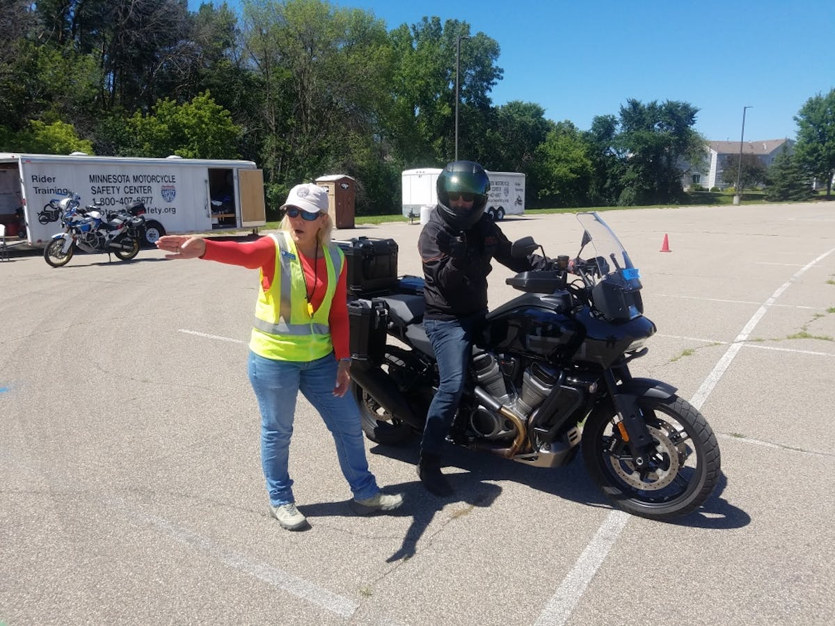 Minnesota Motorcycle Safety Center rider coach Lara Holland gives instructions to class participant Chris Hawkey