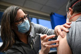 Kari Cline, a nurse and manager with North Memorial Team Member Occupational Health, administered a COVID-19 vaccination to a doctor at North Memorial