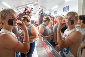 Orono safety Mason Pankonin (42) puts eye black on ahead of his team's game against Robbinsdale Cooper for the first Friday night football of the seas