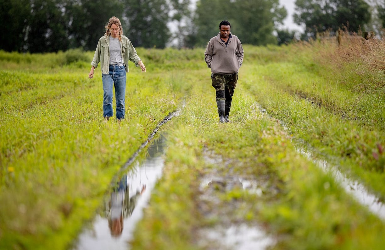 Lucia Possehl, left, with Sharing Our Roots, and co-op farmer Moffatt Odwere, right, analyze the damage to his crops due to recent and ongoing floodin