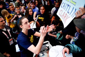 Indiana Fever guard Caitlin Clark signs autographs for fans before the start of WNBA basketball game against the New York Liberty, on May 18 in New Yo