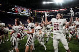 Maple Grove Crimson players celebrate after winning 27-10 over Rosemount.