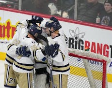 Chanhassen players congratulate relief goalie Grant Atterson at the end of  the third period.