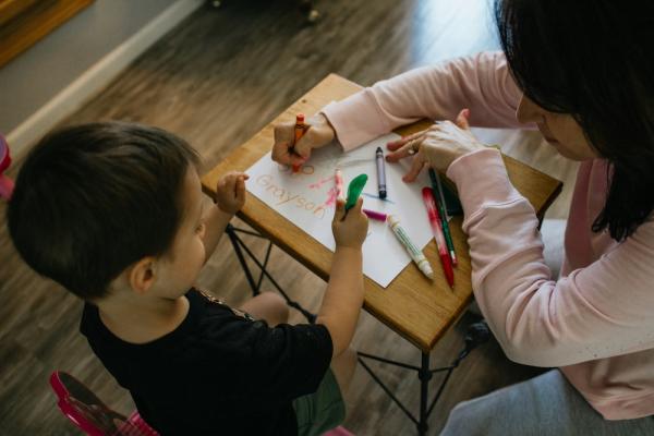 Two people color with markers at a small table