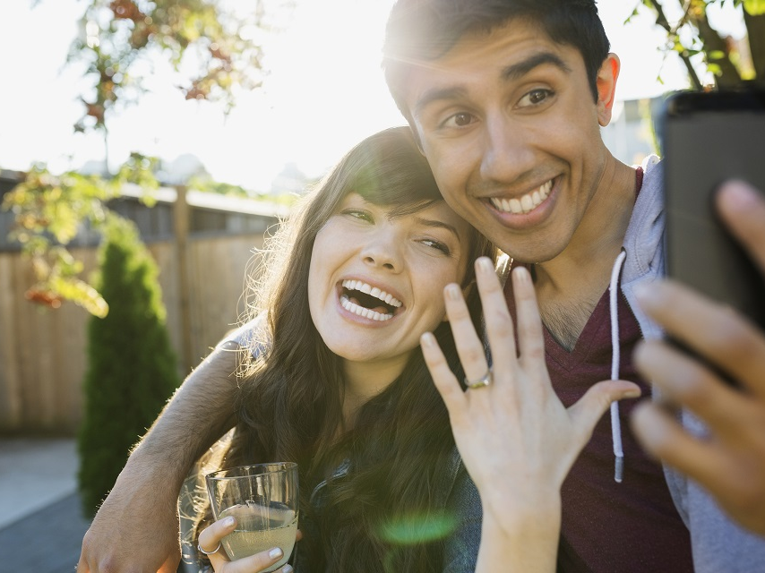 Man and women take a selfie after getting engaged. 