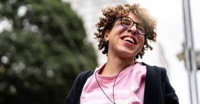 Youth with curly hair in pink shirt