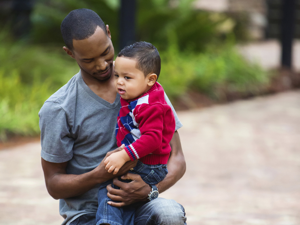 father holding a toddler in his arms