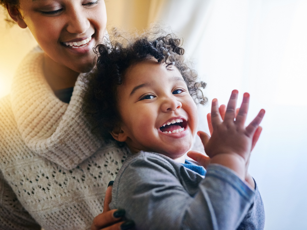 smiling child sitting on mothers lap