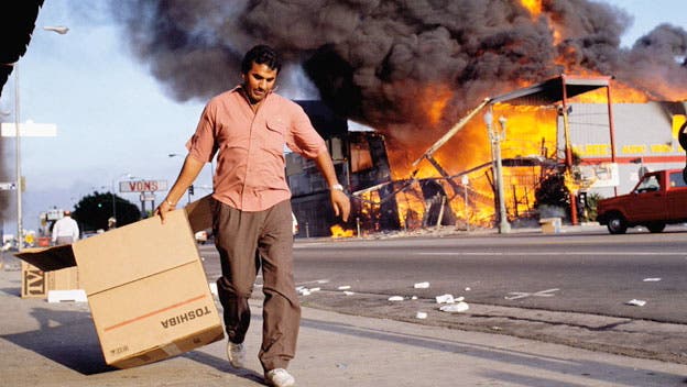 A man walks past a burning building during the Los Angeles riots. In April of 1992, after a jury acquitted the police officers involved in the beating of Rodney King, riots broke out throughout South Central Los Angeles, killing 55 people, injuring another 2,000, and causing more than $1 billion in damage.