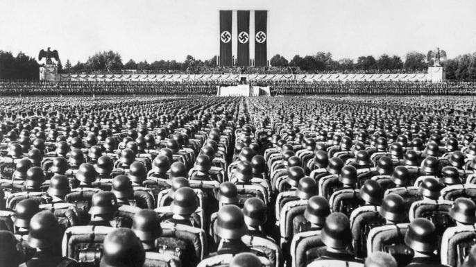 A huge crowd of soldiers stands at attention beneath the reviewing stand at a 1936 Nazi rally in Nuremberg, Germany.