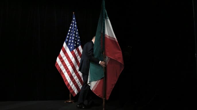 A staff removes the Iranian flag from the stage after a group picture with foreign ministers and representatives of Unites States, Iran, China, Russia, Britain, Germany, France and the European Union during the Iran nuclear talks at Austria International Centre in Vienna, Austria on July 14, 2015. Major powers clinched a historic deal aimed at ensuring Iran does not obtain the nuclear bomb, opening up Tehran's stricken economy and potentially ending decades of bad blood with the West. AFP PHOTO / POOL / CARLOS BARRIA / AFP / POOL / CARLOS BARRIA