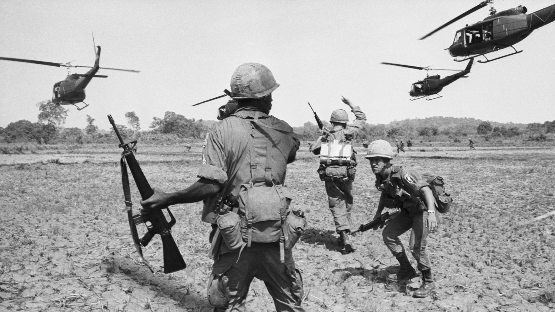 American Paratroopers in field Below Helicopters in South Vietnam(Original Caption) 5/31/1965-Bien Hoa, South Vietnam: United States paratroopers spread out after disembarking from helicopters during a co-ordinated exercise, the first in which all elements of the 173rd Airborne were used. Communist forces are reported to be making heavy attacks against units of the South Vietnamese army and have caused heavy casualties.
