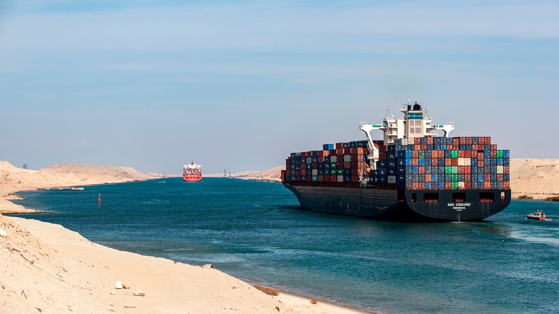 EGYPT-POLITICS-TRANSPORT-SUEZ-CANAL-HISTORYThis picture taken on November 17, 2019 shows the Liberia-flagged container ship RDO Concord sailing through Egypt's Suez Canal in the canal's central hub city of Ismailia on the 150th anniversary of the canal's inauguration. - One hundred and fifty years after the Suez Canal opened, the international waterway is hugely significant to the economy of modern-day Egypt, which nationalised it in 1956. The canal, dug in the 19th century using "rudimentary tools" and which links the Mediterranean to the Red Sea, was opened to navigation in 1869 and was expanded in 2015 to accommodate larger ships. (Photo by Khaled DESOUKI / AFP) (Photo by KHALED DESOUKI/AFP via Getty Images)