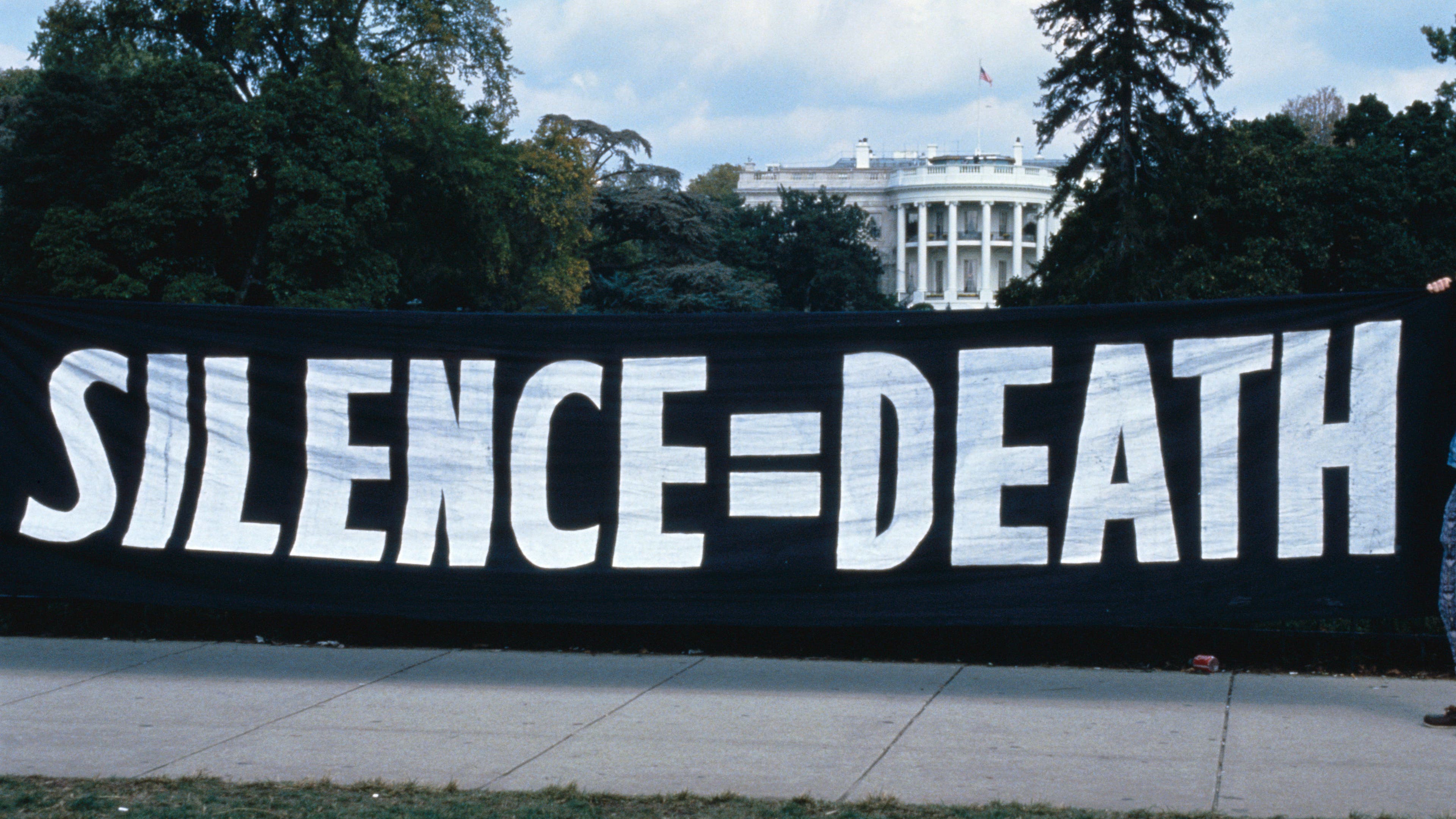 ACT UP activists hang a "silence = death" banner on the White House gates in 1992.