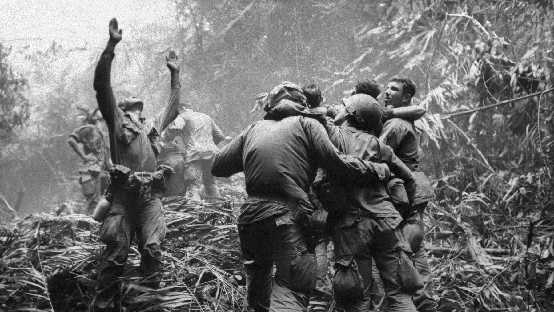 This April 1968 file photo shows the first sergeant of A Company, 101st Airborne Division, guiding a medevac helicopter through the jungle foliage to pick up casualties suffered during a five-day patrol near Hue.