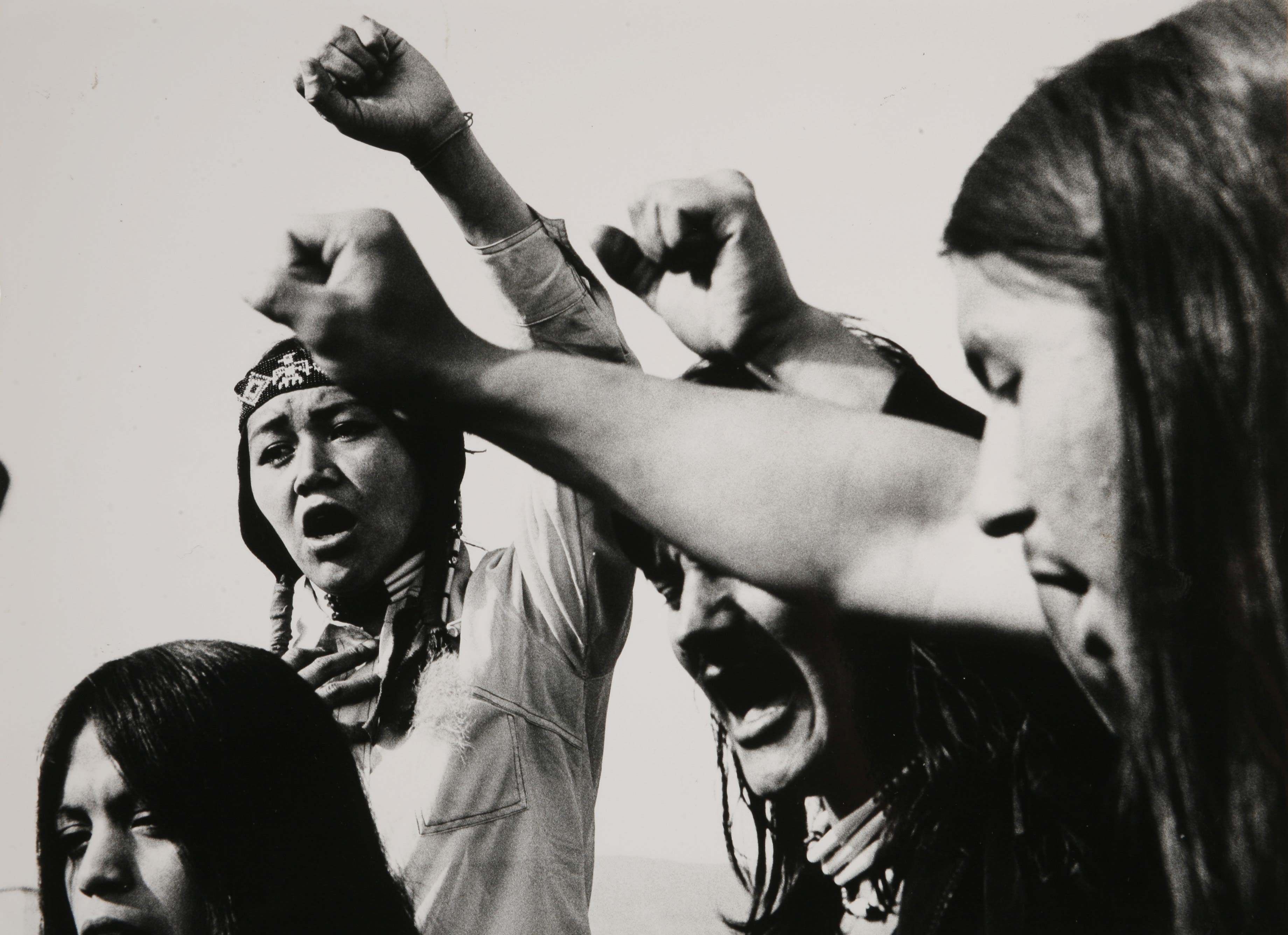 Circa 1975: During a protest gathering, some followers of AIM (American Indian Movement ) raise their fists to swear the Red Power oath.