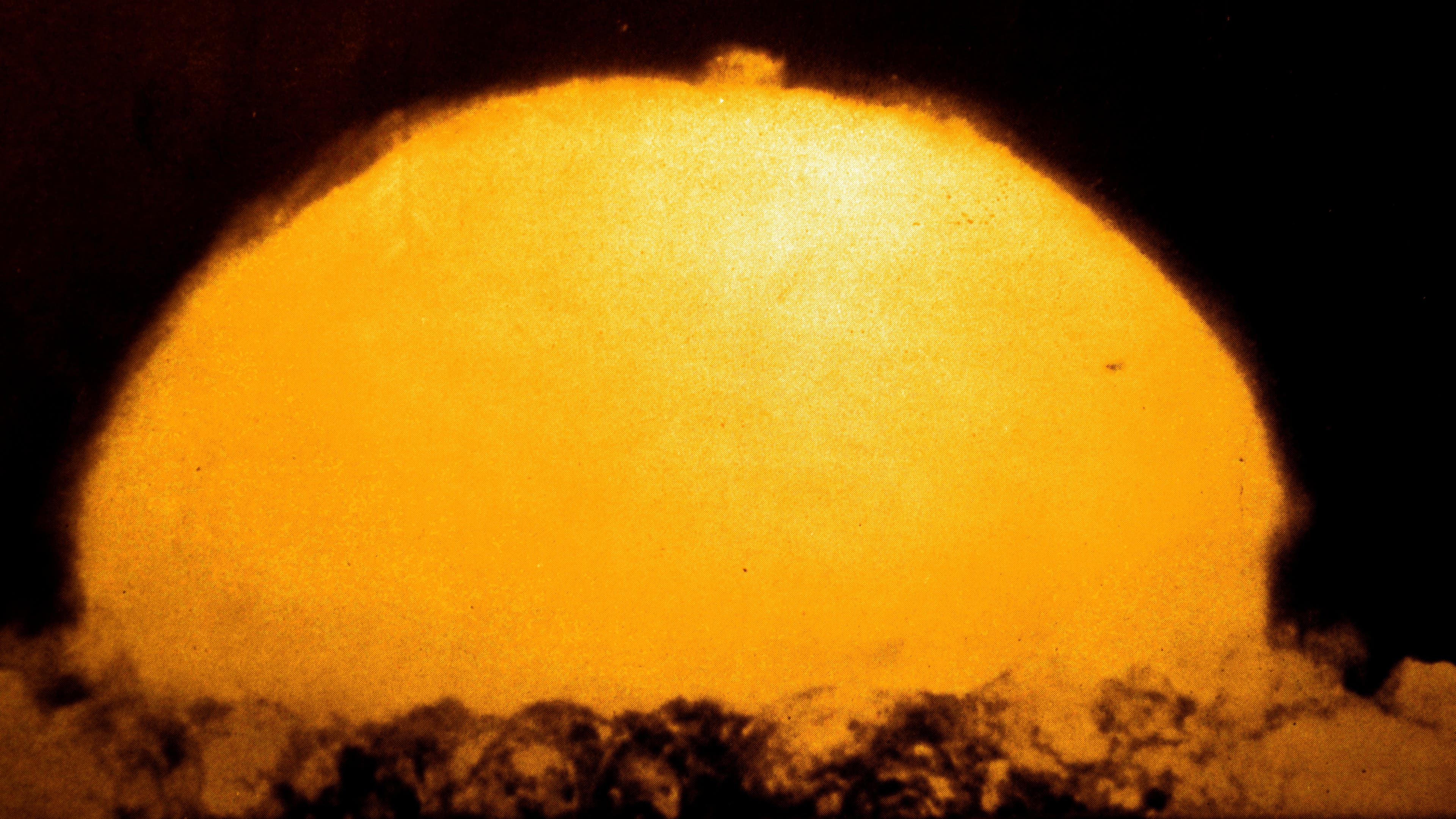 Glowing bright yellow dome-shaped cloud in a dark sky