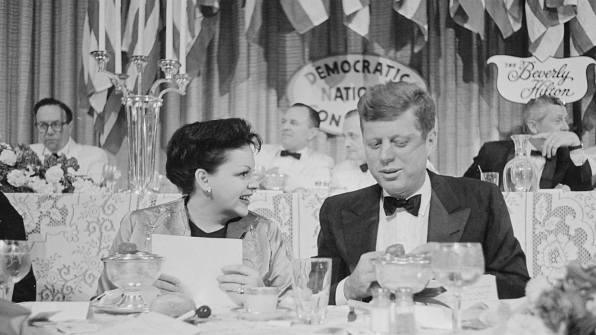 Judy Garland seated next to Senator John F. Kennedy