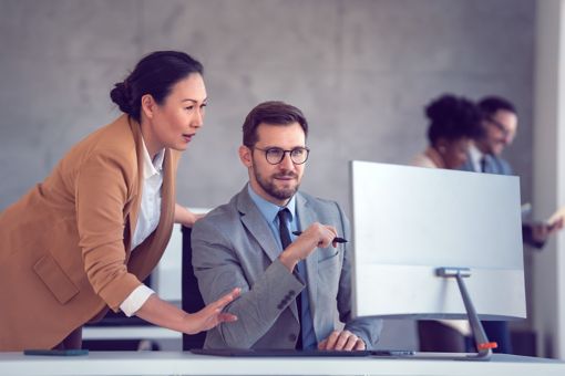 Coworkers working together on desktop