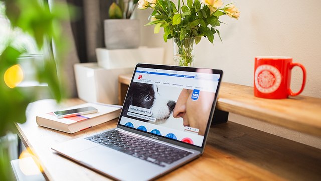 Ein Laptop steht auf einem Schreibtisch, geöffnet ist die Homepage der Uni Hamburg.