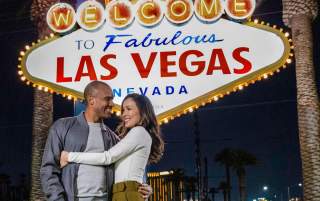 A couple posing happily in front of the famous "Welcome to Fabulous Las Vegas Sign".