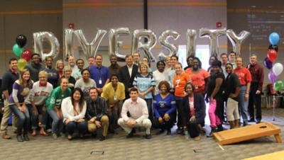 A diversity networks employee resource group in front of nine balloons spelling DIVERSITY